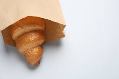 Beyaz zemin üzerinde taze kruvasan olan kağıt torba. Metin için boşluk