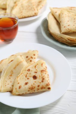 Beyaz ahşap masada leziz krepler, yakın plan.