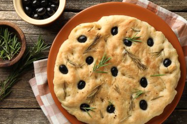 Lezzetli, zeytinli ve biberiyeli Focaccia ekmeği, ahşap masa, düz yatıyordu.