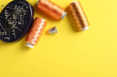 Sarı arka planda farklı dikiş malzemeleri var. Metin için boşluk