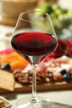 Red wine and different snacks served on table, closeup clipart