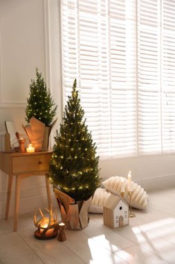 Noel ışıkları ve diğer dekorları olan küçük ladin ağaçları.