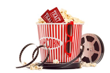 Lezzetli patlamış mısır, film makarası, bardaklar ve sinema biletleri beyaza izole edilmiş.