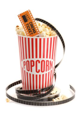 Lezzetli patlamış mısır, film makarası ve sinema bileti beyaza izole edilmiş.