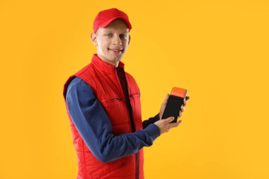 Sarı arka planda ödeme terminali olan mutlu kurye