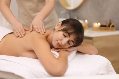 Genç bir kadın güzellik salonunda masaj yaptırıyor.