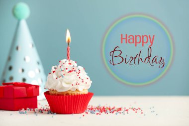 Doğum günün kutlu olsun tebrik kartı. Açık mavi arka planda yanan mumu olan tatlı kek