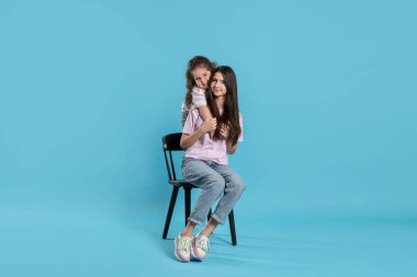 Açık mavi arkaplanda güzel kız kardeşlerin portresi