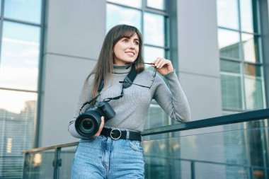 Binanın yakınında dijital kamerası olan profesyonel bir fotoğrafçı.