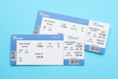 Seyahat acentesi. Açık mavi arka planda uçuş biletleri, üst görünüm