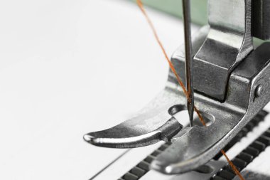 Beyaz arka planda ipliği olan dikiş makinesi, makro görünüm. Metin için boşluk