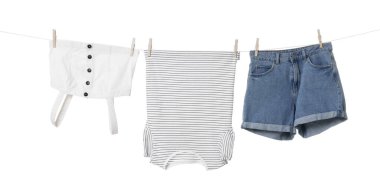 Different clothes drying on laundry line against white background