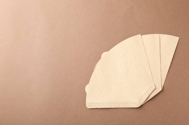 Kahverengi arka planda kağıt kahve filtreleri, düz yatış. Metin için boşluk