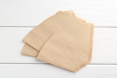 Beyaz ahşap masada bir sürü kağıt kahve filtresi var.