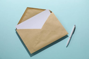 Üstü açık mavi arkaplanlı, üzerinde mektup ve kalem olan Kraft kağıt zarfı. Tasarım için model