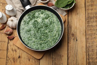 Tahta masada servis edilen nefis ıspanak sosu.