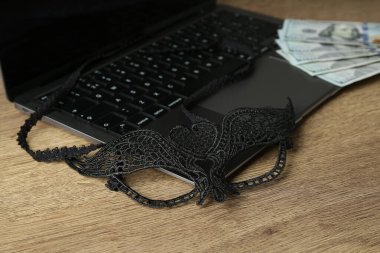 Seks işi. Maskeli ve paralı bir dizüstü bilgisayar.