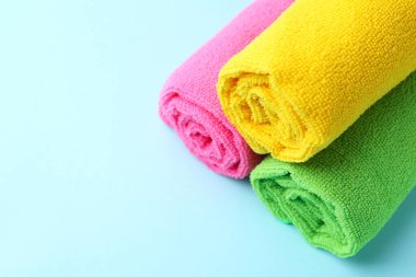 Açık mavi arka planda farklı mikrofiber kumaşlar sarılmış. Metin için boşluk