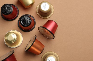 Kahverengi arka planda farklı kahve kapsülleri, düz yatış. Metin için boşluk