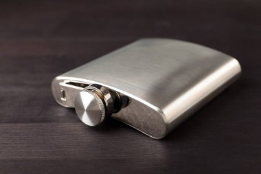 Ahşap masada bir cep şişesi, yakın plan.