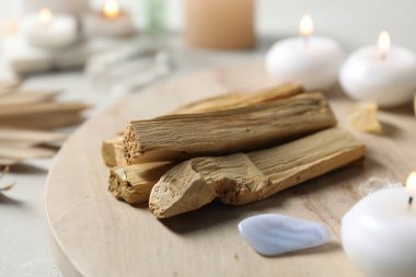 Palo Santo çubukları ve değerli taşlar ışık masasında, yakın plan.