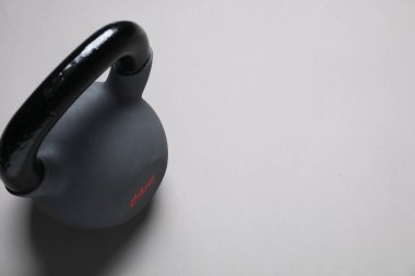 Açık gri arka planda bir kettlebell. Metin için boşluk