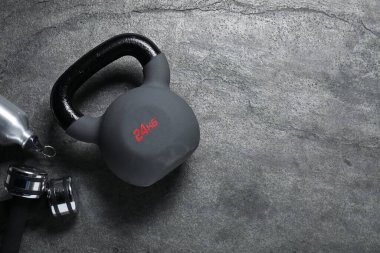 Kettlebell ve dambıllar gri arka planda, düz yatıyordu. Metin için boşluk