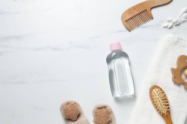 Beyaz mermer arka planda bebek yağı ve banyo aksesuarları. Metin için boşluk