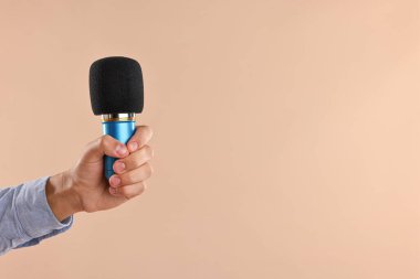 Bej arka planda mikrofonu olan adam, yakın plan. Metin için boşluk