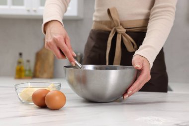 Beyaz mermer masada hamur yapan bir kadın, yakın plan.