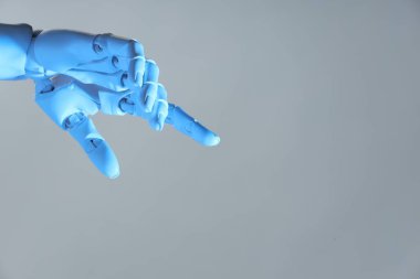 Yapay zeka. Robot el gri arkaplanda bir şeye işaret ediyor, metin için boşluk