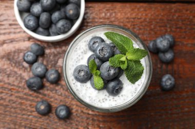 Yaban mersinli nefis chia pudingi ve ahşap masada nane şekeri.