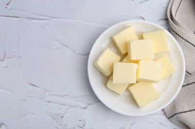 Beyaz desenli masa üzerinde taze tereyağı parçaları, üst manzara. Metin için boşluk