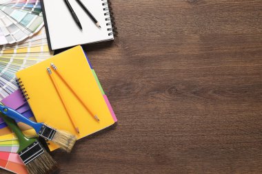 Düz kompozisyon, farklı ressamların aletleriyle ahşap masa üzerinde, metin için boşluk. Dekorasyon ve tasarım