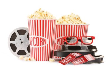 Lezzetli patlamış mısır, film makaraları, bardaklar ve sinema biletleri beyaza izole edilmiş.