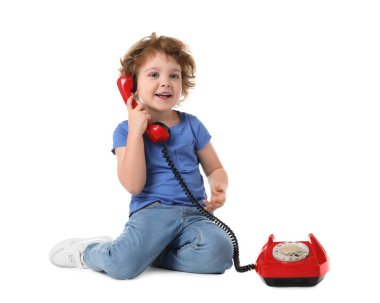 Beyaz arka planda telefonu olan sevimli küçük bir çocuk.