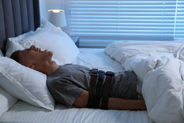 Uyurgezer bir adam yatakta çığlık atıyor.