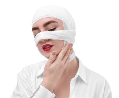 Beyaz arka plandaki estetik ameliyattan sonra burnu tıbbi bandaja sarılı bir kadın.