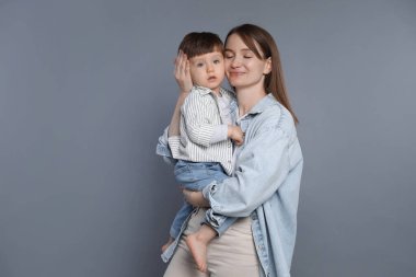 Anne ve küçük oğlu gri arka planda. Metin için boşluk