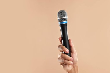 Bej arka planda mikrofonu olan adam, yakın plan. Metin için boşluk