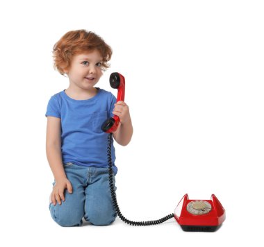 Beyaz arka planda telefonu olan sevimli küçük bir çocuk.