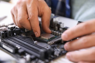 Beyaz masadaki ana karta bilgisayar çipi takan adam, kapat