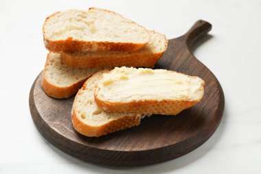 Beyaz masada tereyağlı taze ekmek, yakın plan.