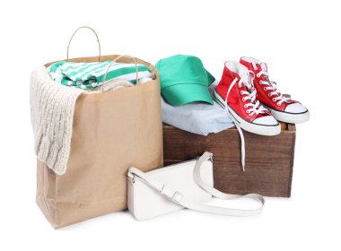 Packed used clothes, bag and shoes isolated on white clipart