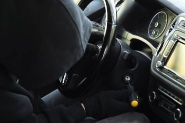 Hırsız tornavidayla ateşleme düğmesine basmaya çalışıyor. Araba kaçırma.