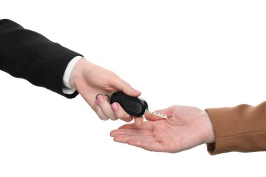 Satıcı beyaz arka plandaki müşteriye araba anahtarı veriyor, yakın plan. Otomatik satın alınıyor