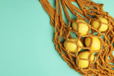 Turkuaz arka planda limonlu Macrame alışveriş torbası. Metin için boşluk
