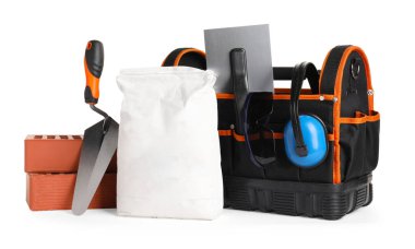 İnşaat araçlarıyla dolu çanta ve beyaz üzerine izole edilmiş yapı malzemeleri