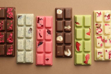 Bej arka planda farklı lezzetli çikolatalar, düz yatış.