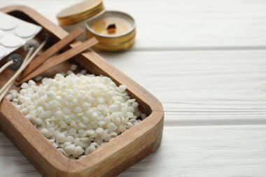 Soya cilası, fitil, çıkartma ve mum beyaz ahşap masa, yakın plan. Metin için boşluk